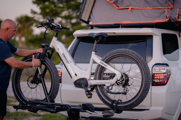 a man putting a bike on the back of a truck
